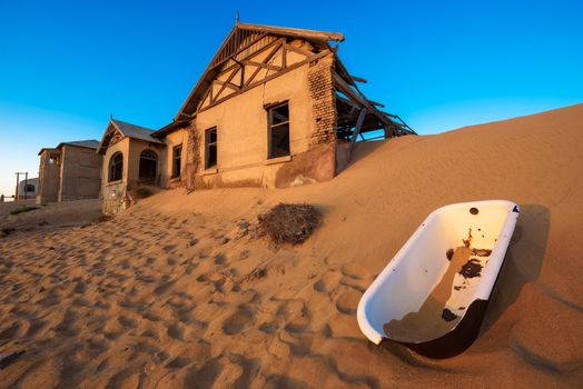 Empty bathtub placed outside in the sand desert around the ghost town of Kolmanskop.