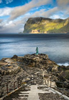 Statue of Selkie or Seal Wife in the village of Mikladalur on Kalsoy, Faroe islands. Selkies are mythological creatures found in Irish, Scottish, and Faroese folklore. Long exposure.