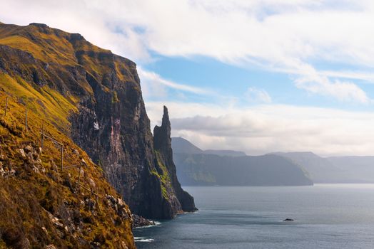 Trollkonufingur rock, also called The Witch's Finger on the island of Vagar. Trollkonufingur is a freestanding sea stack rock on the east of Sandavagur village on the Faroe Islands.