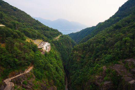 View from the Contra Dam over a hydroelectric power plant on the Verzasca River in Ticino, Switzerland. This dam is also known as the Verzasca Dam and the Locarno Dam.