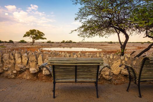 Bench at the waterhole of Okaukuejo Campsite in Etosha National Park, Namibia.