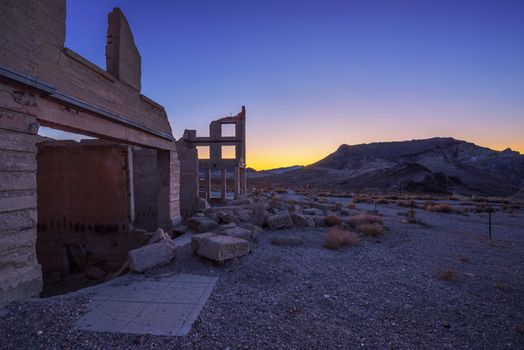 Sunrise above ruined building in the town of Rhyolite, Nevada. This ghost town is located in Nye County among Bullfrog Hills near Death Valley.