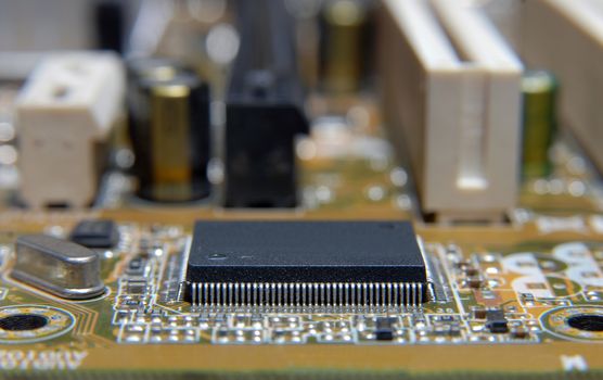 Electronic chip on circuit board. Macro, shallow DOF.