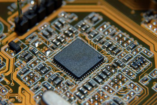 Electronic chip on circuit board. Macro, shallow DOF.