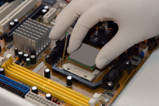 woman's hand in glove sets the CPU to motherboard