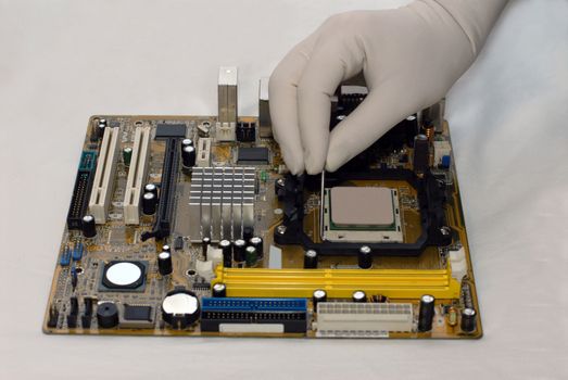 woman's hand in glove sets the CPU to motherboard