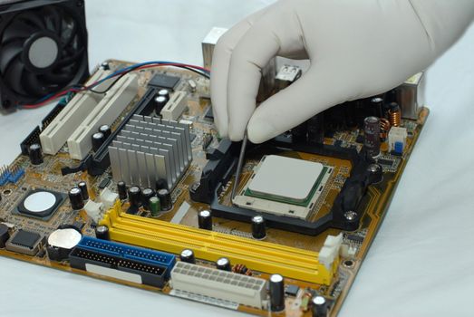 woman's hand in glove sets the CPU to motherboard