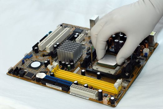 woman's hand in glove sets the CPU to motherboard