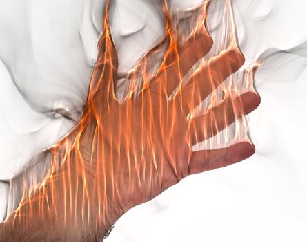 A human hand on fire burning with orange flames and some smoke in front of a white background