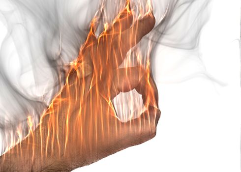 A human hand on fire burning with orange flames and some smoke in front of a white background