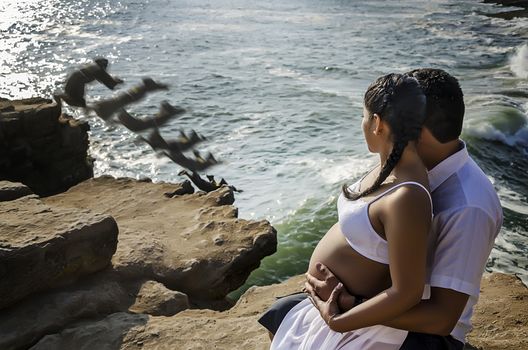 Future mom and couple watching a man jump to the cliff