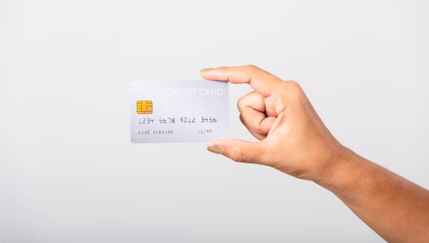 Close up hand of Asian woman she holding bank credit card for pay money online shopping, studio shot isolated on white background