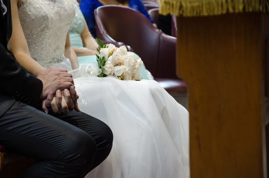 Bride and groom holding hands and the bride with a bouquet of roses