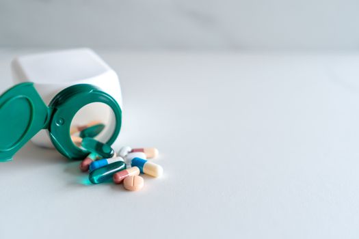 Top view of medicine tablets pour from pills bottle of marble texture white background. Health care medical lifestyle trend concept.