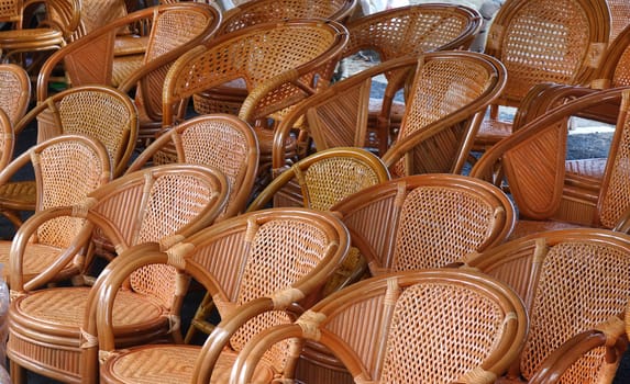 Handcrafted rattan and bamboo chairs for sale at an outdoor market