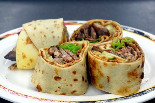 Rolled pancakes stuffed with beef, spring onions and sweet bean sauce is a popular Chinese snack