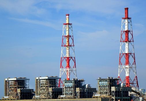 A large thermal power plant with red chimneys