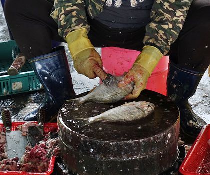 A fishmonger in Taiwan cleans fish at a local wet market.
