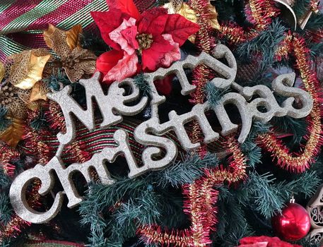 Christmas tree detail with Merry Christmas letters and colorful decorations

