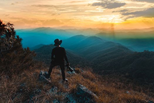 Silhouette of man hold up hands on the peak of mountain,success concept