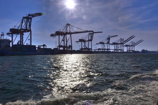 A row of loading cranes for containers are seen in port
