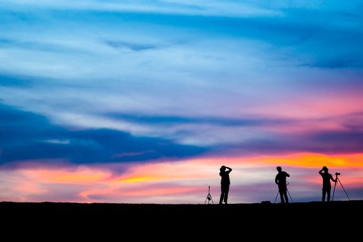 Silhouette of man hold up hands on the peak of mountain,success concept 