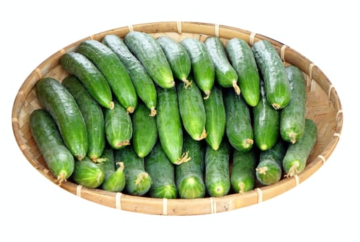 A wicker basket with fresh cucumbers at a local market
