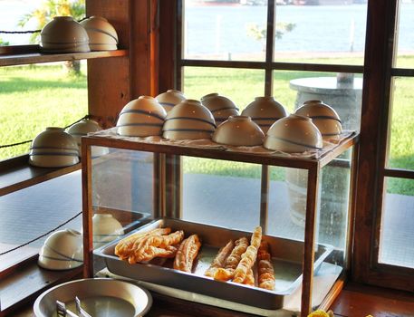 A stall sells Chinese fried breadsticks and bowls of soybean milk
