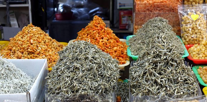 A market vendor sells dried fish and shrimps
