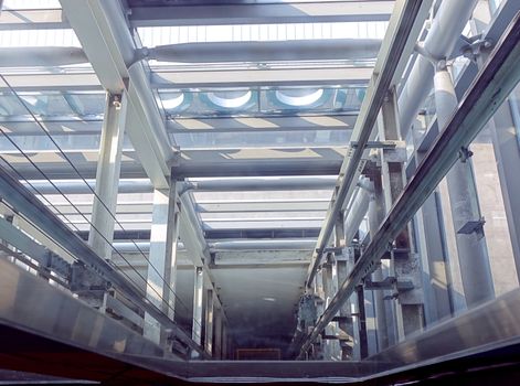 View into an elevator shaft that has glass on three sides
