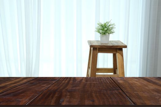 plant pot on wooden bar stool chair beside see through sheer window curtain