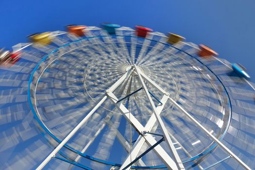 A ferris wheel with colorful cabins at a local fun fair