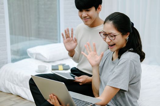 asian woman man talking with colleagues in online video conference meeting. work at home social distancing concept