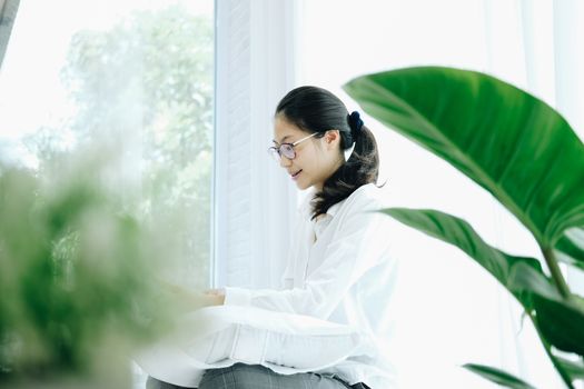 asian woman using computer laptop on bed in bedroom. work remotely  at home. leisure lifestyle
