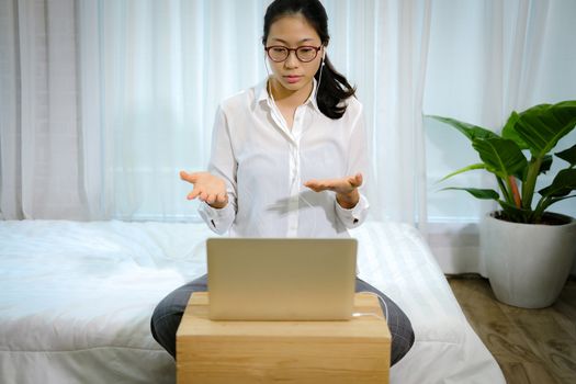 asian woman businesswoman talking with colleagues in online video conference meeting. work at home social distancing concept