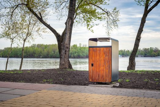 A wooden and metallic trash bin in the Natalka park of Kiev, Ukraine, close to the Dnieper river in spring