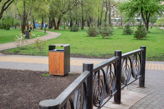 A wooden and metallic trash bin in the Natalka park of Kiev, Ukraine, close to the Dnieper river in spring