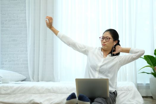 tired lazy asian woman using computer. freelancer work remotely at home. leisure lifestyle