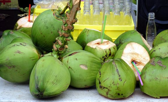 A street vendor sells fresh coconut milk straight from the fruit
