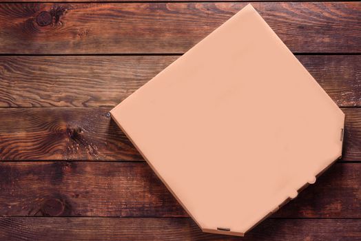 Pizza box Blank Mockup of brown Cardboard for delivery on a wooden background