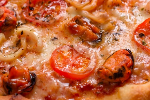 Seafood Italian pizza with shrimp, squid, mussels, fresh herbs and mozzarella on a
dark background. Tasty sliced pizza with seafood and tomato on a concrete background