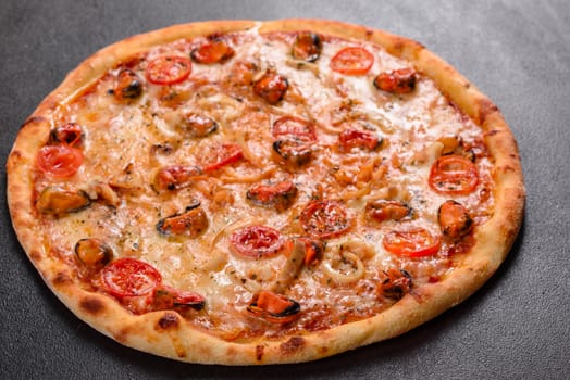 Seafood Italian pizza with shrimp, squid, mussels, fresh herbs and mozzarella on a
dark background. Tasty sliced pizza with seafood and tomato on a concrete background