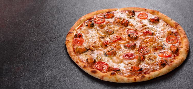 Seafood Italian pizza with shrimp, squid, mussels, fresh herbs and mozzarella on a
dark background. Tasty sliced pizza with seafood and tomato on a concrete background
