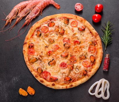 Seafood Italian pizza with shrimp, squid, mussels, fresh herbs and mozzarella on a
dark background. Tasty sliced pizza with seafood and tomato on a concrete background