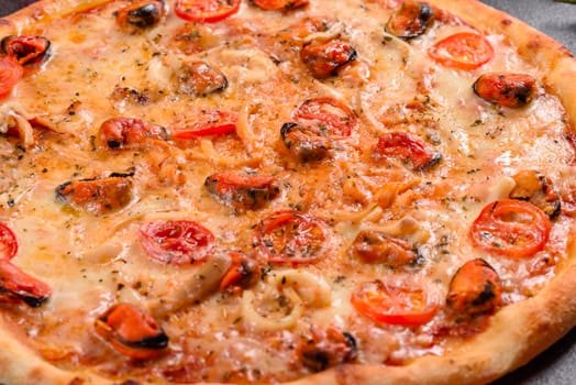Seafood Italian pizza with shrimp, squid, mussels, fresh herbs and mozzarella on a
dark background. Tasty sliced pizza with seafood and tomato on a concrete background