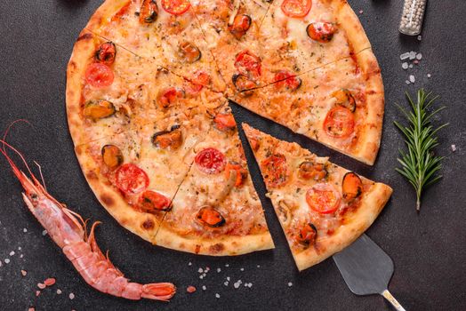 Seafood Italian pizza with shrimp, squid, mussels, fresh herbs and mozzarella on a
dark background. Tasty sliced pizza with seafood and tomato on a concrete background
