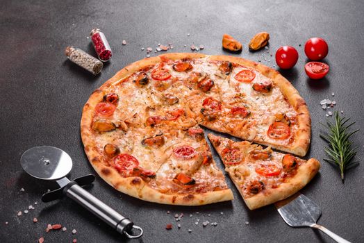 Seafood Italian pizza with shrimp, squid, mussels, fresh herbs and mozzarella on a
dark background. Tasty sliced pizza with seafood and tomato on a concrete background