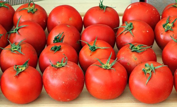 Bright red garden tomatoes are being sold at a farmer market