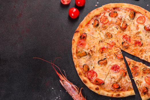 Seafood Italian pizza with shrimp, squid, mussels, fresh herbs and mozzarella on a
dark background. Tasty sliced pizza with seafood and tomato on a concrete background