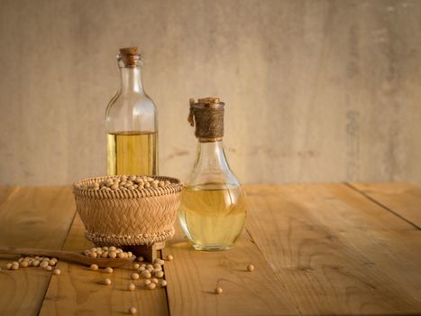 Soy bean and soy oil on a wooden table.